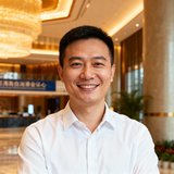 海南自贸港国际会议中心运营总监陈伟的职业形象照，身着白色衬衫，面带微笑